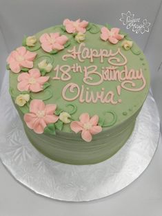 a green birthday cake with pink flowers on it