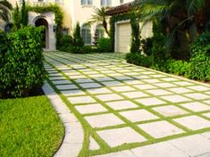 a driveway with grass in front of a house