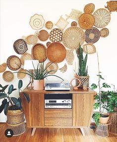 a room filled with lots of plants and wicker baskets on top of a wooden table