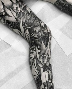 black and white tattoo on the leg of a woman