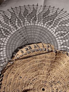 a close up of a straw bag on top of a table with an intricate doily pattern