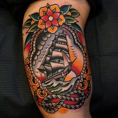 a woman's leg with a ship tattoo on it