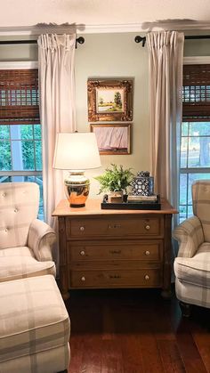 a living room with two chairs and a dresser