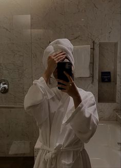 a person taking a selfie in a bathroom with a towel wrapped around their head