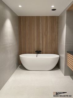 a large white bath tub sitting inside of a bathroom next to a wooden paneled wall