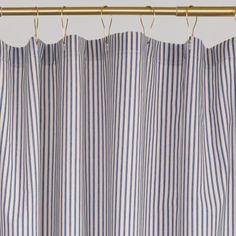 blue and white striped curtains hanging on a gold rod