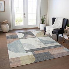 a living room area with a chair and rug on the hardwood floor next to a door