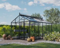 a glass house surrounded by potted plants in the middle of a garden with gravel and rocks