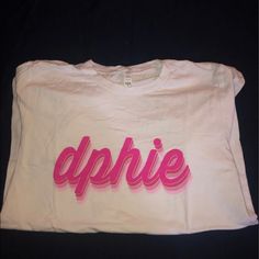 a white t - shirt with the word aphie printed in pink on it