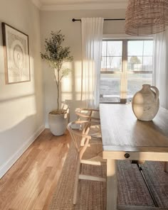 a dining room table and chairs in front of a window