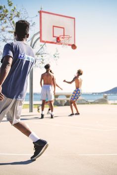 three men playing basketball on an outdoor court