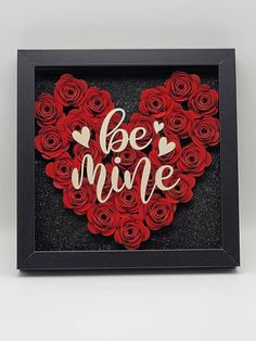 a heart made out of red roses with the words be mine written on it in gold foil