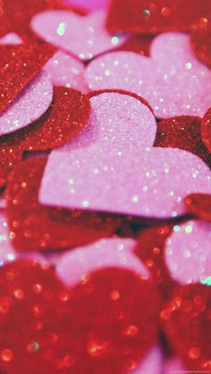 pink and red glitter hearts are on the table