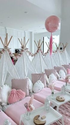 a room with pink couches and white tables