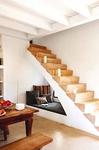 there is a room with stairs and books on the shelves next to the table in front of it