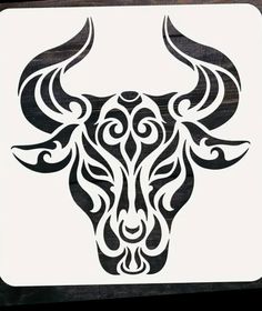 a bull's head is shown in black and white on a square wooden plaque