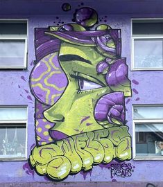 a purple and yellow building with graffiti on it