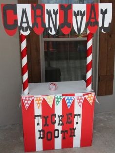 a carnival ticket booth is decorated with candy canes and paper streamers for decoration