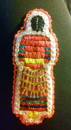 an orange and white beaded cell phone case with a bird on it's back