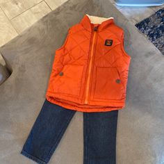 Super Cute Puffer Vest And Pair Of Jeans For Baby Or Toddler. This Was Originally Part Of A 3-Piece Set As Noted On The Tag, But I Couldn’t Find The Third Piece. Perfect For Back To School, Fall Weather, Family Photos, Etc. Jeans: - Navy Denim Color - Size 18 Months - Pull On/Off - Elastic Waistband - 100% Cotton - 4 Belt Loops - Two Front Pockets And Two Back Pockets Vest - Orange Puffer Vest - Sleeveless - Zippered Closure With Neck Protector From Zips At Top - Cream Colored Fleece Like Lining Cute Puffer Vest, Vest And Jeans, Tutu Shirt, Capri Outfits, Pocket Vest, Kids Head, Tunic Leggings, Hearts Girl, Hoodie And Sweatpants