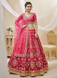 a woman in a pink lehenga with gold embroidery on the waist and sleeves