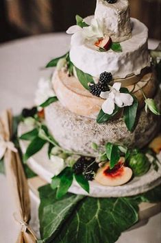 an image of a wedding cake with flowers and leaves on the bottom tier, as seen on instagram