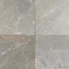 two pieces of gray marble sitting next to each other on top of a tile floor