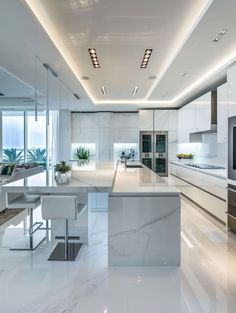 a modern kitchen with marble counter tops and white cabinets