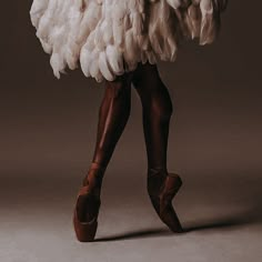 a woman is dressed in an ostrich costume and holding a large bird's wing