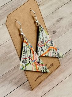 a pair of paper earrings sitting on top of a cardboard box