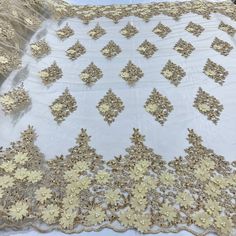 a white table cloth with gold flowers on it