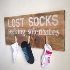 three pairs of socks hang on a sign that says, lost socks seeking solemates