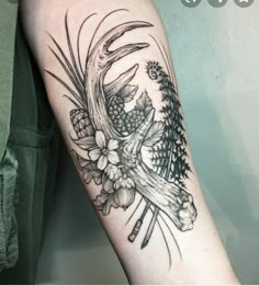 a deer skull with flowers and pine cones on it's back arm tattoo design