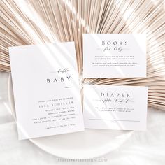 the wedding stationery is laid out on top of a white plate with palm fronds