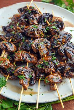 a white plate topped with meat and skewers