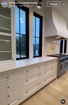 a kitchen with white cabinets and black windows