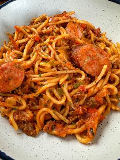 pasta with sausage and tomato sauce in a white bowl