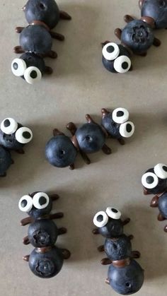 there are some blueberries with googly eyes on them and one is made to look like a bug