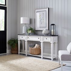 a living room with white furniture and decor