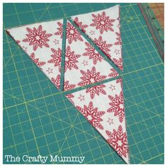 the triangle is made up of red and white snowflakes on green cutting mat