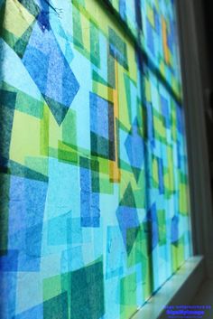 an abstract painting with blue, green and yellow squares on the side of a building