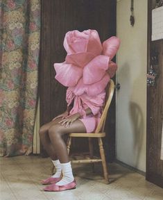 a woman is sitting in a chair with pink flowers on her head and shoes on