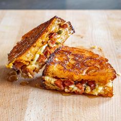 two grilled sandwiches cut in half on a cutting board