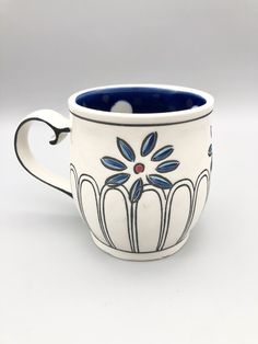 a white and blue coffee cup sitting on top of a table