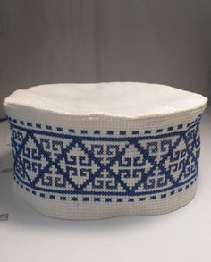 a white and blue basket sitting on top of a table