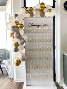 a champagne bar with balloons and wine glasses hanging from the wall in front of it