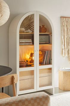 an arched glass cabinet with books inside