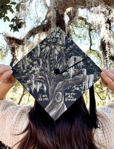 a person wearing a graduation cap with trees on it