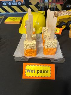 there are some popsicles made to look like construction trucks on the table with construction signs