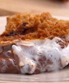 a piece of cake on a plate with icing and crumbs